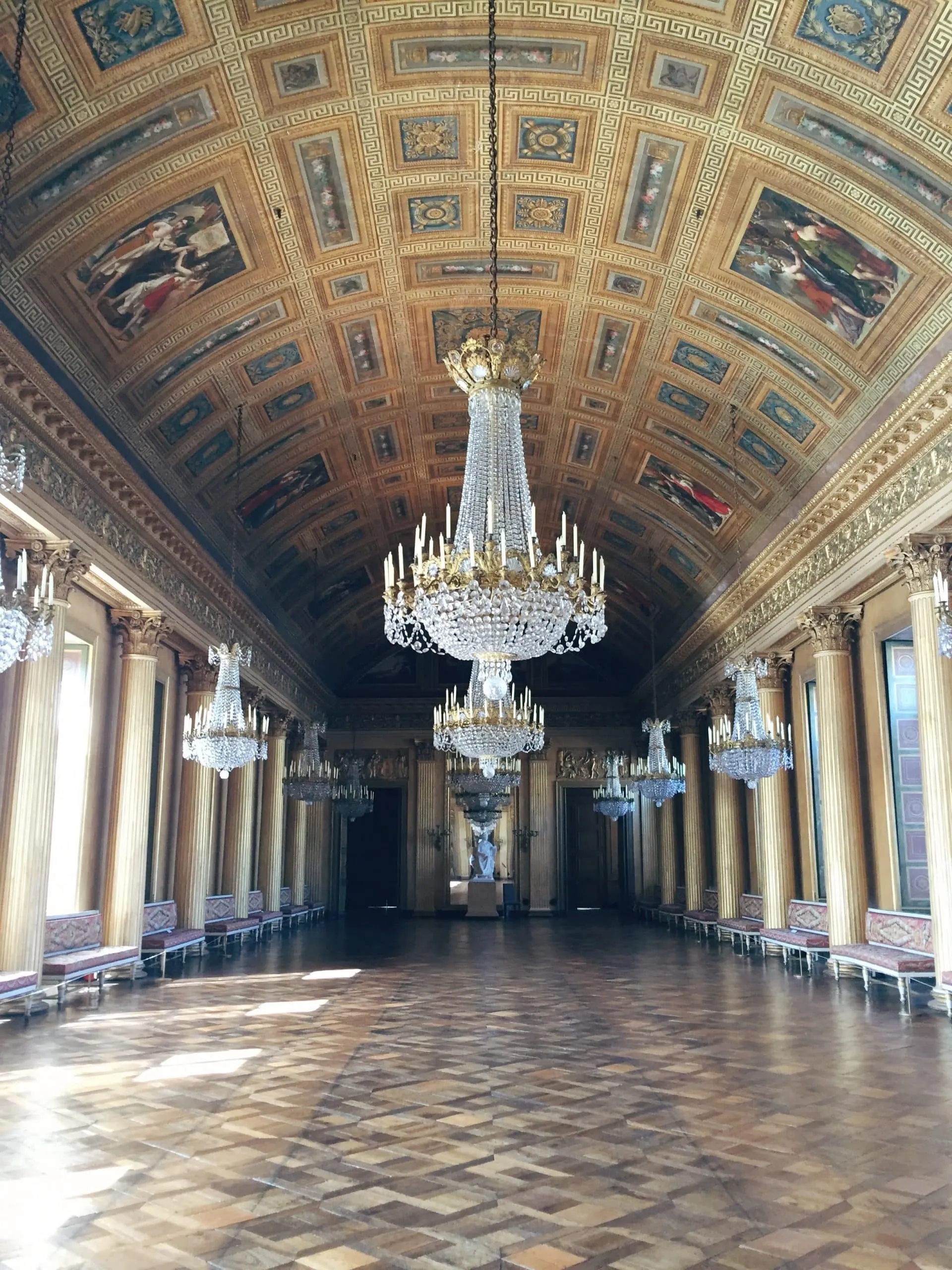 Hall orné d'un haut plafond voûté, de grands lustres en cristal, de parquet, de hautes fenêtres et d'œuvres d'art classiques - une caractéristique étonnante de l'Hôtel de Harlay, l'hébergement renommé de Compiègne.