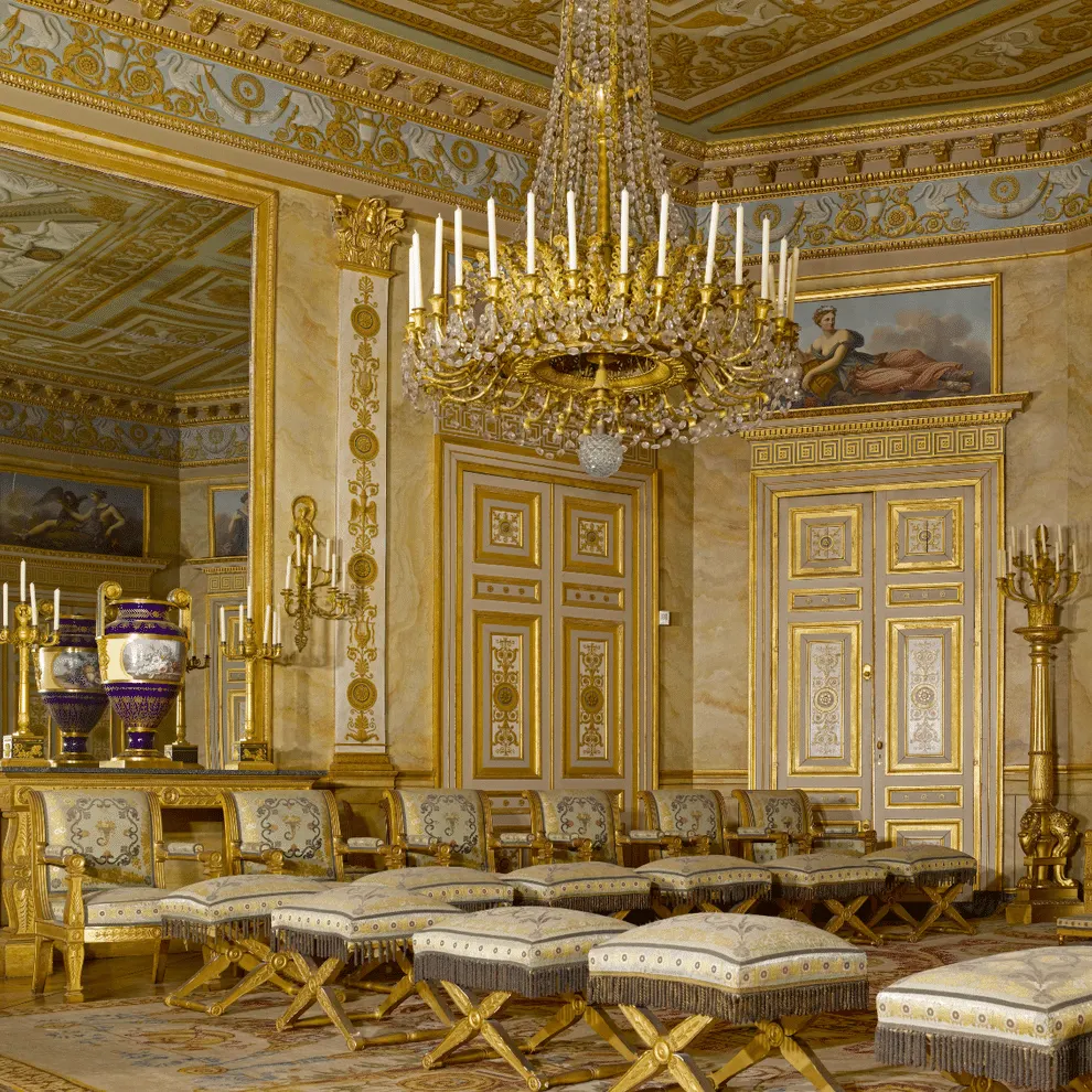 Chambre ornée à l'Hôtel de Harlay avec des murs et un plafond dorés, un grand lustre en cristal, des tabourets rembourrés, des vases décoratifs et des œuvres d'art classiques - un point fort élégant de l'Hébergement Compiègne.
